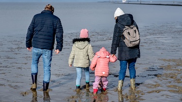 Familie läuft im Schlick | Bild: Picture alliance Familie läuft im Schlick | Bild: Picture alliance