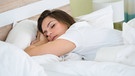 Junge Frau schläft im Schlafzimmer. Im Sommer können die Nächte bei hohen Temperaturen zur Qual werden und euch den Schlaf rauben. Damit ihr auch bei Hitze gut schlafen könnt, haben wir fünf Tipps für euch. | Bild: picture alliance / PantherMedia | Andriy Popov