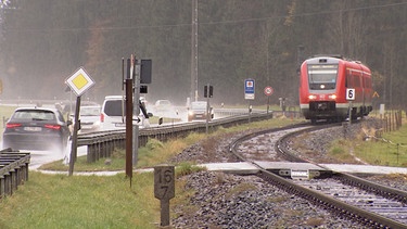Autos und ein Zug an einem unbeschrankten Bahnübergang | Bild: Bayerischer Rundfunk 2020