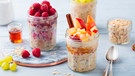 Verschiedene Früchte wie Himbeeren und Pfirsichstückchen auf leckerem Bircher Müsli im Glas | Bild: mauritius images / Anna Pustynnikova / Alamy / Alamy Stock Photos