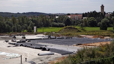 Bauarbeiter bei der Sanierung des Teersees in Rositz (2011). Jahrzehntelang wurden Teerrückstände in einem See nahe des Werkes unter freiem Himmel deponiert. Es sind eines der größten und schwierigsten Altlasten in Thüringen. Die Sanierung kostete ca. 180 Millionen Euro. | Bild: picture-alliance/dpa